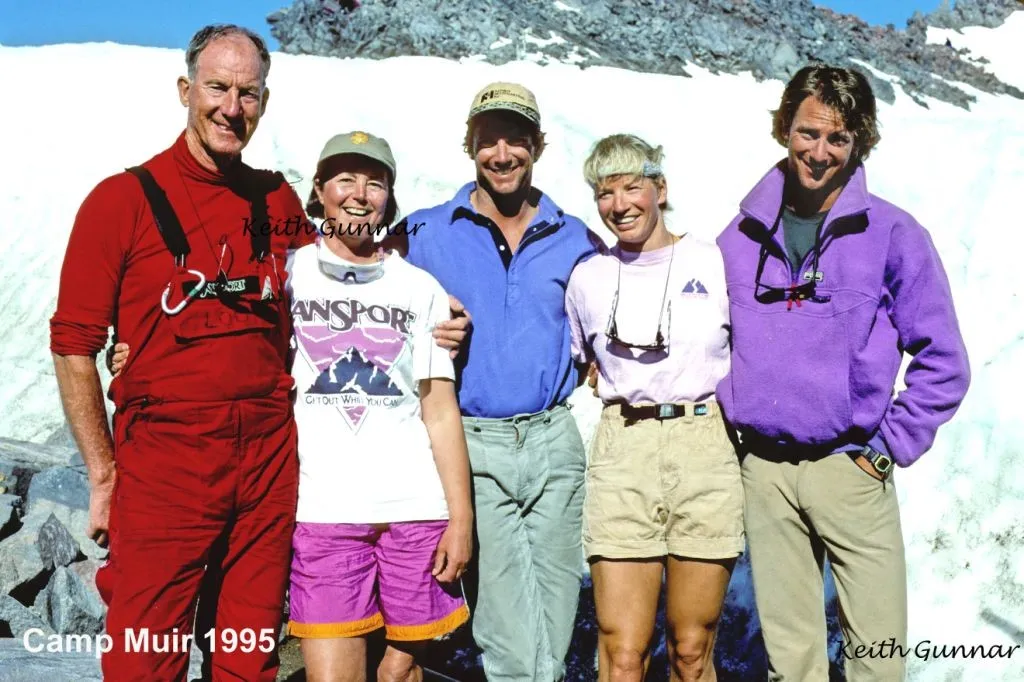 Five hikers smiling and posing in front of snow and rocks at Camp Muir in 1995.